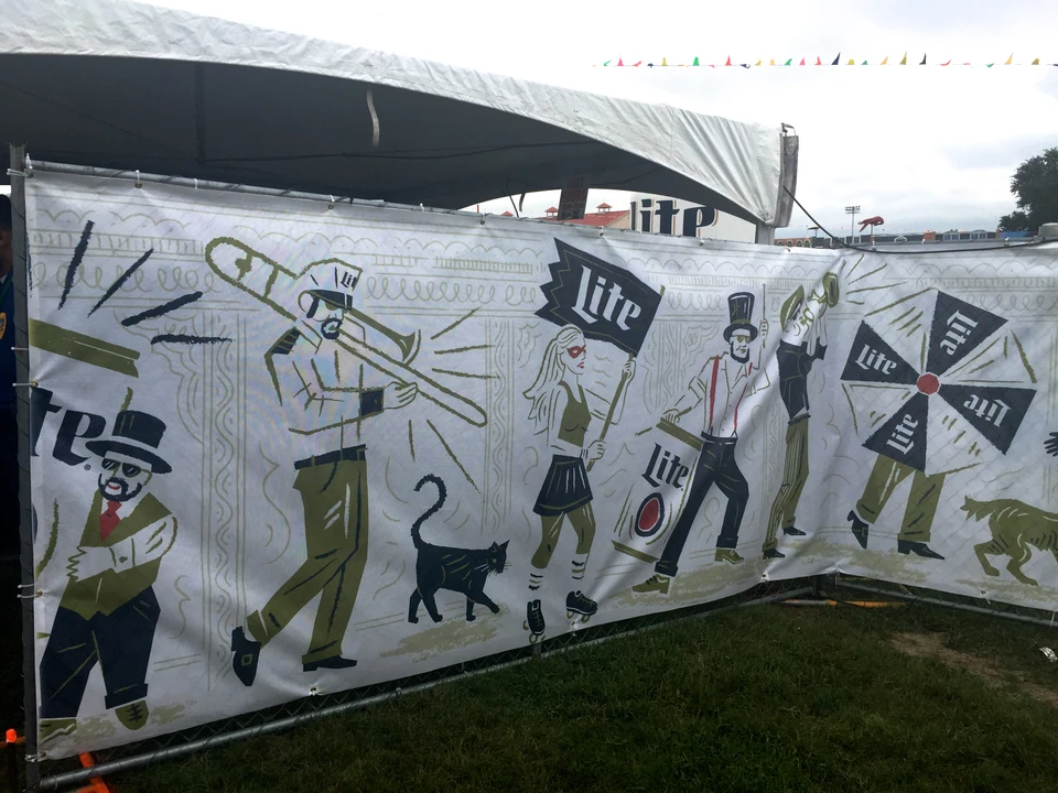 Miller Lite illustrated musicians and dancers applied to festival fencing and tent signage.
