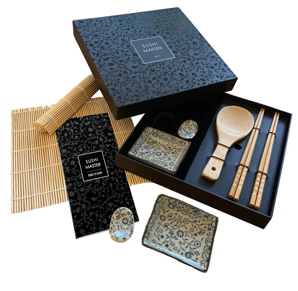 The Sushi Master Set: a black gift box beside two blue-and-white ceramic trays and rests, bamboo chopsticks, a bamboo spoon, rolling mats and the Sushi Master Guide